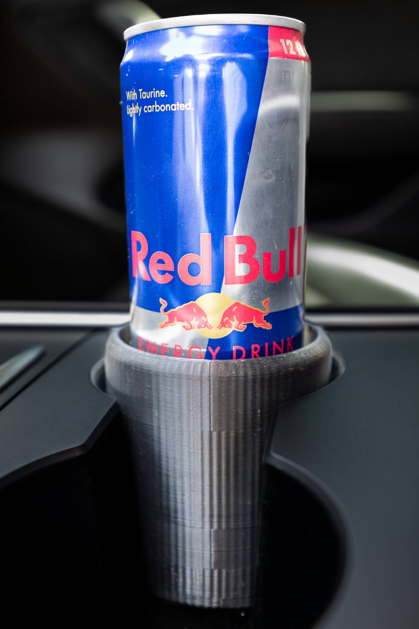 Close-up showing snug fit of skinny energy drink can in car holder