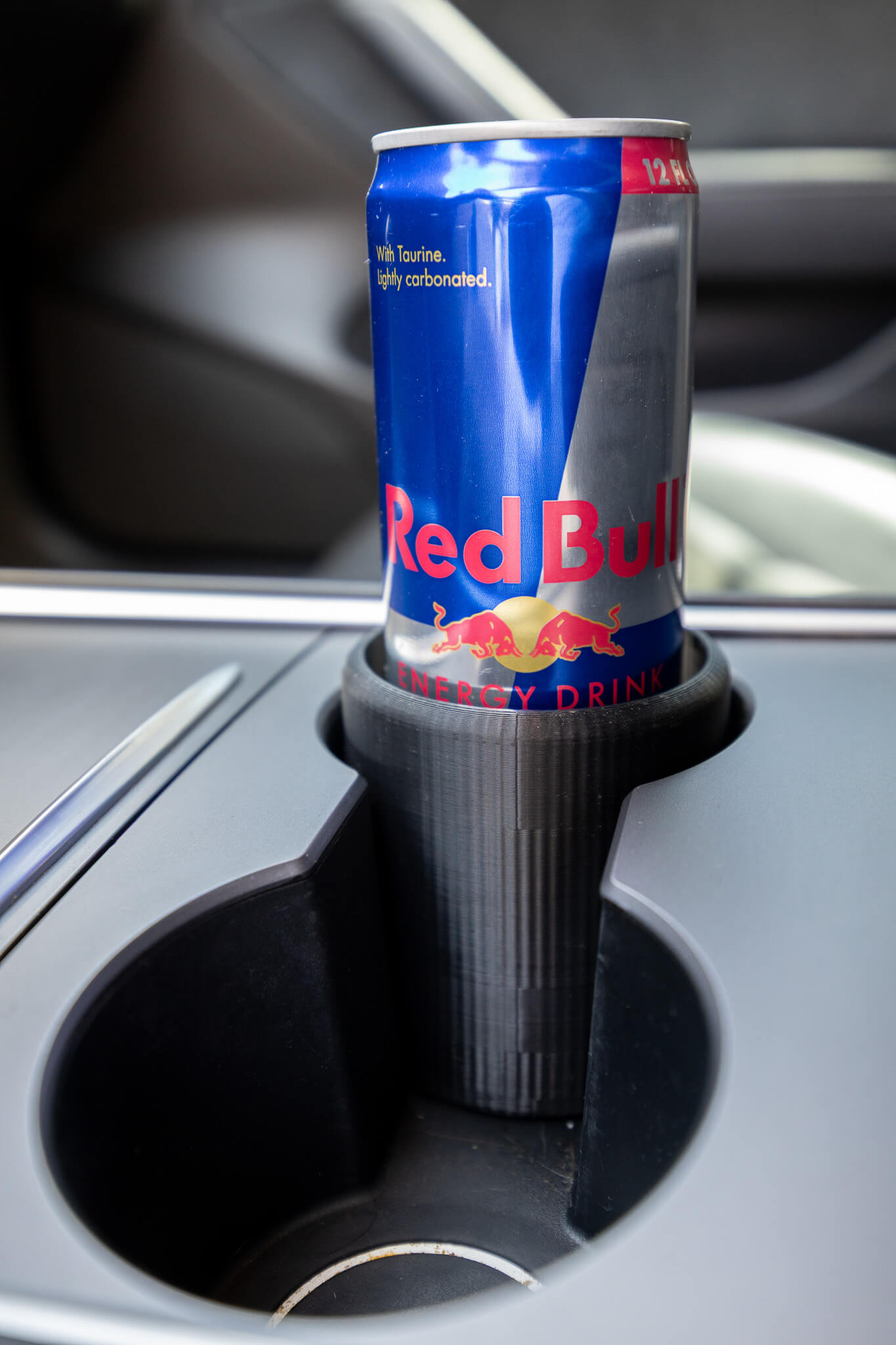 Skinny can holder inside vehicle cup holder, prevents spills while driving